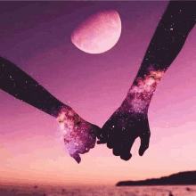 a couple holding hands with the moon behind them