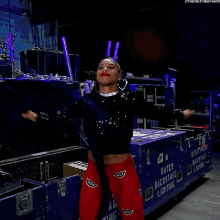 a woman in a black sequined top and red pants is standing in front of a blue box that says best friends backstage