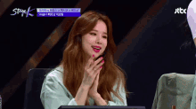 a woman sitting in front of a screen with jtbc written on the bottom