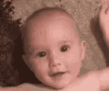 a close up of a baby 's face with a blurred background .