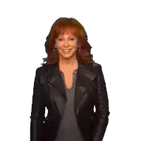 a woman with red hair is wearing a black jacket