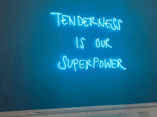 a neon sign that says " tenderness is our superpower "