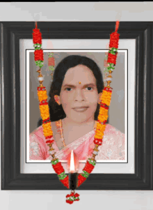 a framed picture of a woman with a candle hanging around her neck