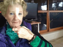 an older woman holds a snake in front of a samsung television