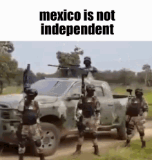 a group of soldiers standing next to a truck with the words `` mexico is not independent '' written on it .