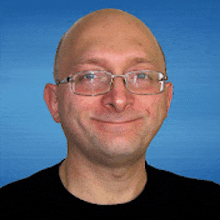 a bald man wearing glasses is smiling for the camera