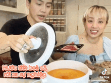 a man and a woman are cooking in a kitchen and a tiktok video is being shared