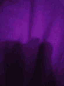 a person 's shadow is visible on a purple background .