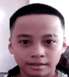 a close up of a young boy 's face with a very short haircut .