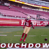 a football player is jumping in the air on a field in front of a sign that says faithful & the roughdown