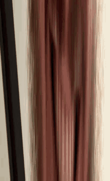 a blurry picture of a person 's legs with a black pole in the background