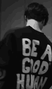 a black and white photo of a man wearing a shirt that says be a good human