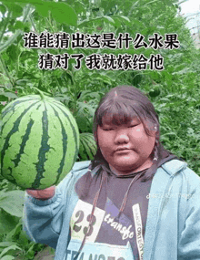 a woman is holding a watermelon in her hands in a garden .