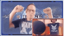 a man wearing a shirt that says kart is flexing his muscles in front of a microphone .