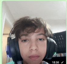 a young boy wearing headphones with the time 18:36 on the bottom right