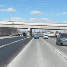 a highway with cars driving under a bridge and a sign that says ' i 'm sorry ' on it