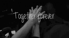 a black and white photo of two people holding hands with the words together forever written above them