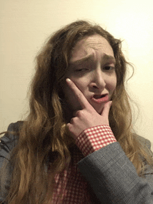 a woman making a funny face with her fingers on her chin