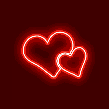 two red neon hearts on a black background