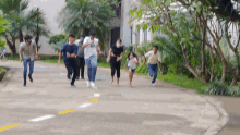 a group of people running down a street with one wearing a shirt that says ' i love you '