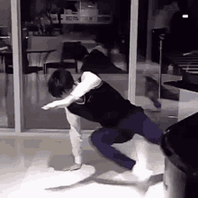 a man is doing a trick on a skateboard in a living room while a woman watches .