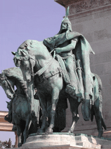 a statue of a man riding on the back of a horse with a shield on his head