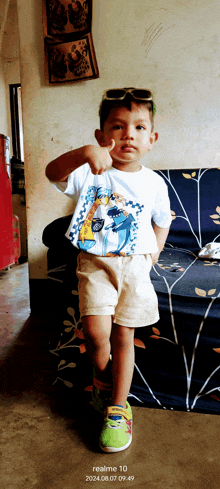 a young boy wearing sunglasses and a shirt that says ' realme 10 ' on the bottom