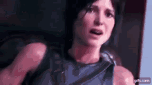 a close up of a woman 's face in a video game with a shocked look on her face .