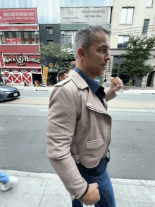 a man is walking down a street in front of a rock horse restaurant