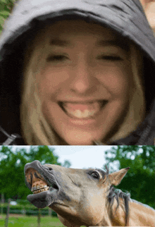 a woman wearing a hooded jacket smiles next to a horse with its mouth open