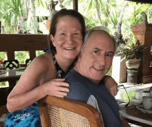 a man and woman are posing for a picture and the man is wearing a blue shirt that says hawaii