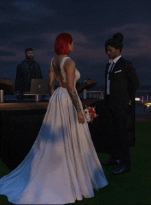 a bride in a wedding dress stands next to a groom in a suit