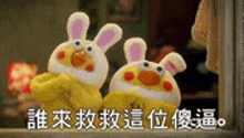 a couple of stuffed animals standing next to each other with chinese writing on the bottom .