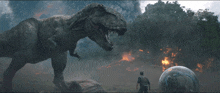 a man stands in front of a t-rex in a scene from a movie