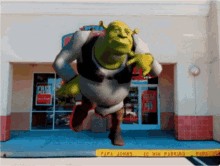 shrek is running in front of a pizza hut