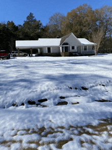 a red truck is parked in front of a snowy house