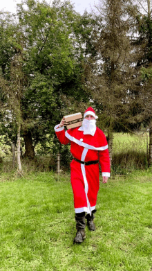 a man dressed as santa claus is carrying a box that says amazon