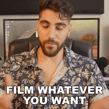 a man with a beard is sitting in a chair and says film whatever you want