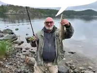 a man is holding a fishing rod and a fish