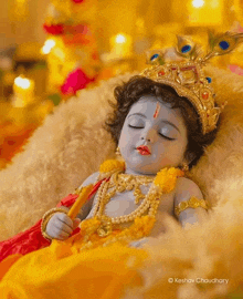 a baby krishna is laying on a blanket with his eyes closed .