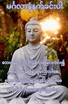 a statue of a buddha sitting under a tree with a quote in a foreign language .