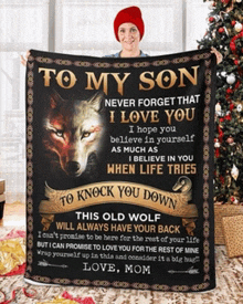 a woman is holding a blanket that says to my son