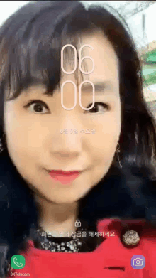 a woman 's face is displayed on a phone screen with the time of 6:00