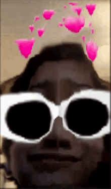 a close up of a person wearing sunglasses with pink hearts in the background