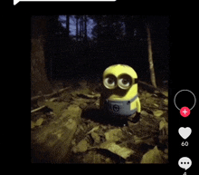 a toy minion is standing in the woods at night .