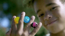 a young boy is holding a bunch of balls in his hands .