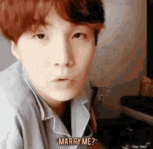 a young man with red hair is looking at the camera and says `` marry me '' .