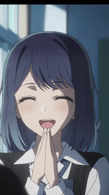 a girl with blue hair is smiling and holding her hands together