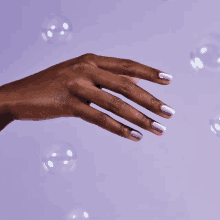 a close up of a woman 's hand with bubbles behind it