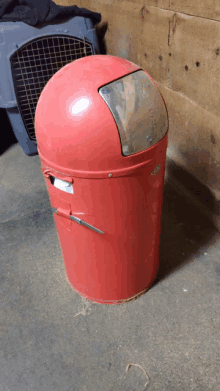 a red trash can with a lid that says ' a ' on it